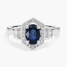 an oval blue sapphire and baguette diamond ring in white gold with diamonds surrounding it