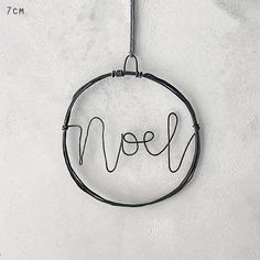 the word love is written in cursive writing on a wire hanging from a hook