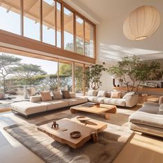 a living room filled with lots of furniture and large windows over looking the water in front of it