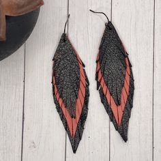 Genuine leather feather earrings feature a beautiful black and coral layered leather These are handmade my me and each pair will be slightly different Approximately 3.5” long surgical steel Hypoallergenic, nickel and lead free Handmade by me Handmade Black Faux Leather Jewelry, Black Leather Earrings As A Gift, Handmade Black Leather Earrings, Adjustable Black Faux Leather Earrings, Closet Revamp, Leather Feather Earrings, Biker Babe, Leather Projects, Feather Earrings