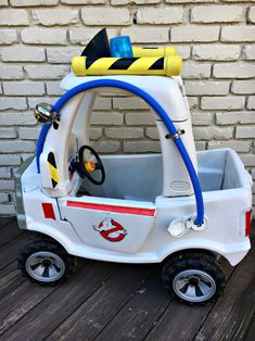 a white toy car with a yellow and blue hose attached to it's roof