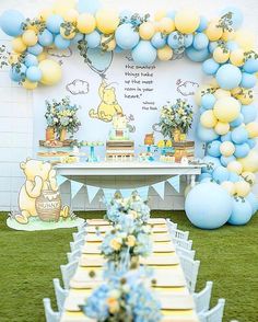 a winnie the pooh birthday party with balloons and dessert table set up on grass