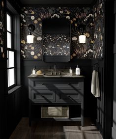 a bathroom with black walls and floral wallpaper on the vanity, along with two mirrors