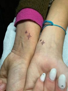 two people with matching tattoos on their wrists, one has a star and the other has a heart