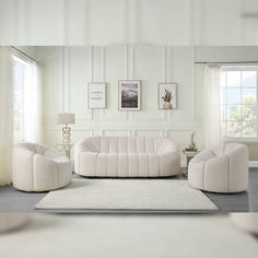 a living room with white furniture and pictures on the wall