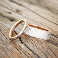 two wedding rings sitting on top of a wooden table