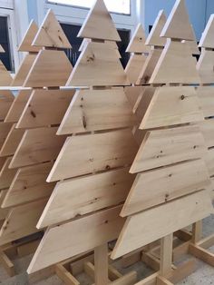 wooden christmas trees are lined up in rows