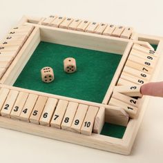 two dices in a wooden box with numbers on the side and one is missing