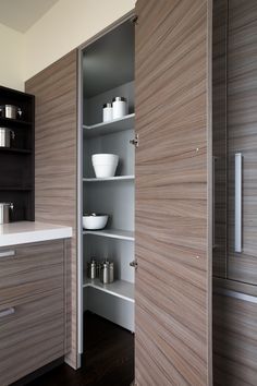 an image of a kitchen with wooden cabinets and white bowls on the counter top in front of it