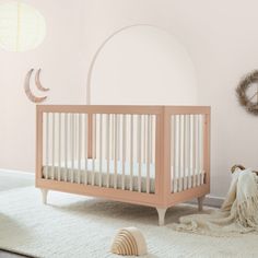 a baby's room with a crib, rug and wall decor in pastel tones