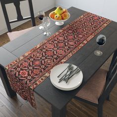 the table is set with two place settings and fruit on the plate next to it