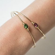 18 carat (750 thousandths) recycled gold bangle and green tourmaline in closed setting surrounded on both sides by a double ring, with lobster clasp.

 Gold weight: 3.35 g
 Tourmaline carat weight: 0.81 ct
 Diameter: 57.20 x 48 mm Yellow Gold Stackable Oval Jewelry, Oval Yellow Gold Stackable Jewelry, Oval Stackable Yellow Gold Jewelry, Yellow Gold Oval Bangle With Gemstone, Luxury Tourmaline Jewelry For Formal Occasions, Classic Tourmaline Jewelry With Polished Finish, Adjustable Yellow Gold Gemstone Jewelry, Oval Gemstone Bangle For Formal Events, Luxury Oval Tourmaline Jewelry