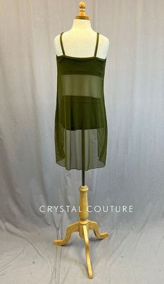 a dress on a mannequin with a white base and green sheer fabric over it