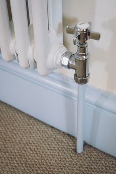 the water faucet is attached to the radiator in the room with carpeted flooring