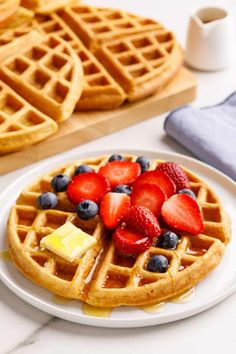 waffles topped with fruit and syrup on a white plate