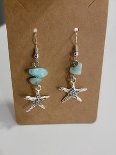 Beautiful handmade drop earrings with a silver starfish and shells. Handmade Starfish Earrings For Beach, Silver Dangle Earrings For The Beach, Handmade Beachy Drop Earrings, Handmade Star Shaped Jewelry For Vacation, Handmade Star-shaped Jewelry For Vacation, Beachy Handmade Drop Earrings, Nickel-free Silver Earrings For Vacation, Starfish Charm Dangle Jewelry, Summer Starfish Charm Drop Earrings