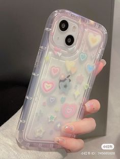 a woman's hand holding an iphone case with hearts on it