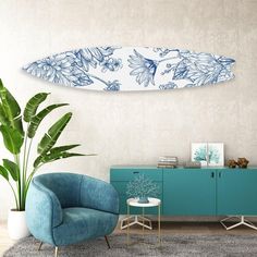 a living room with a blue chair and a white surfboard hanging on the wall