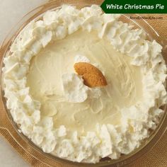 a white christmas pie with whipped cream and a cookie on top