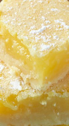 three pieces of lemon bars stacked on top of each other with powdered sugar on them