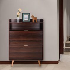 a wooden dresser with two drawers in a room