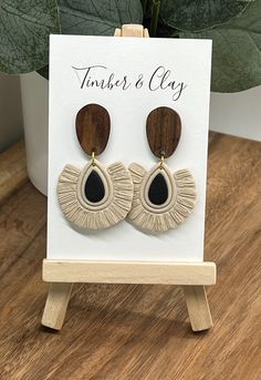 a pair of wooden earrings sitting on top of a table next to a potted plant