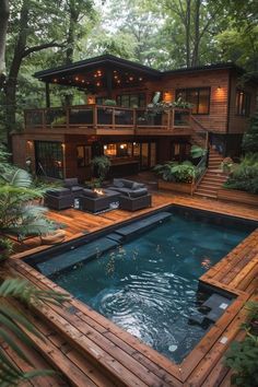 an outdoor pool surrounded by wooden decking and patio furniture in front of a house