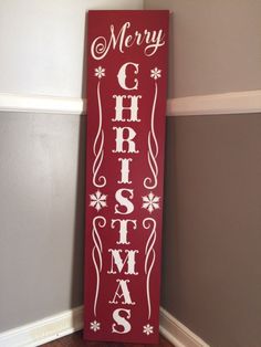 a merry christmas sign hanging from the side of a wall in a room with wood floors