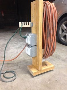 an electrical device is attached to a wooden stand with wires and plugs in it