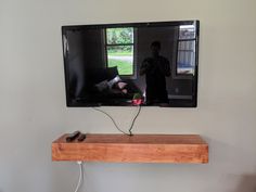 a flat screen tv sitting on top of a wooden shelf