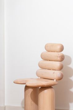 a stack of rocks sitting on top of a wooden bench next to a white wall