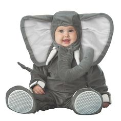 a baby sitting on the ground wearing an elephant costume