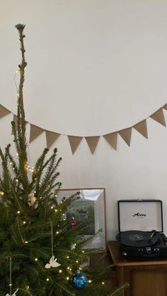 a small christmas tree in front of a record player