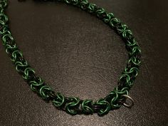 This is a sturdy black and green necklace done in a weave commonly known as byzantine.  It is lightweight and made of anodized aluminum. The charm ring does not come with it unless you ask for it in a buyer's note.  This necklace can be personalized to be at your desired length. Colors can be personalized as well! Send me a message to inquire about alternative colors. ABOUT MY PROCESS I have a rig and a drill. With these two things I coil my own wire, and I individually snip each ring from the coil. What this meticulous process means is that the ends of the closed rings don't lie flush with each other. This is what is referred to as machine cut. COLORS Everyone's monitor is different. Expect slight variations in color. Byzantine Necklace, Charm Ring, Charm Rings, Anodized Aluminum, Green Necklace, Choker Necklaces, Green And Black, Chain Styles, Favorite Jewelry