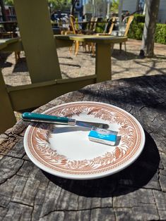 a plate with a toothbrush on it sitting on a wooden table in front of chairs