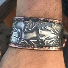 Thank you for looking at this handmade one of a kind totally awesome Embossed cuff that I designed. I used new solid sterling silver embossed it, and forged it in copper we can make for men and woman, also we have this in solid sterling silver. Please request with or without patina (This particular cuff is fitted for a wrist size 7.5-8.5 , (the models are 6.5- 8.5). We will create a cuff in your size, which is fitted for you). The weight will differ if your size is not the same slightly adjustable  About 60 grams about 1.5 inches wide handmade hand forged, Rustic, handcrafted original design  Travel, hawaii , Men and women, Matching set, flower, floral,  Healing Energy, Arthritis, Goth ,Gothic Armor, Steampunk Artisan Boho Rocker, Biker, Forged, Form Folded Grunge ,Punk, Punk Rock, 24 Gaug Gothic Armor, Hawaii Men, Boho Rocker, Travel Hawaii, Totally Awesome, Grunge Punk, Healing Energy, Handmade Artisan, Hand Forged