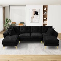 a black sectional sofa sitting on top of a white rug