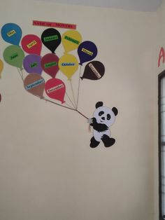 there is a panda bear holding balloons on the wall