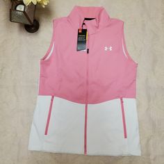 Pink And White Fitted, Full Zip, Cold Gear Sleeveless Jacket Vest. Zippered Pockets. White Sleeveless Outdoor Vest, White Sleeveless Top With Pockets, White Sleeveless Outdoor Outerwear, Sporty Spring Outerwear Vest, White Vest Outerwear For Spring, White Sports Tops With Pockets, Casual White Sports Vest, White Vest With Pockets For Spring, Casual White Vest Outerwear