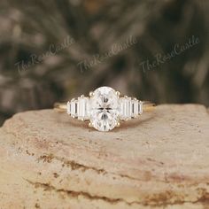 a white diamond ring sitting on top of a rock