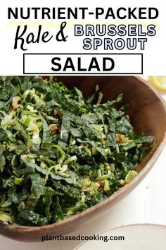 a wooden bowl filled with greens and nuts next to a white plate full of salad