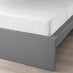 a close up of a mattress on a bed frame in a room with wood floors