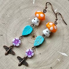 These earrings are comprised of lamp work mushroom, dyed Howlite leaf & Czech glass flower beads and copper plated bee charms. They are 3'' in length including their copper played ear wires and have a 2.5'' drop. At only 0.3 ounces they are very lightweight and perfect for extended wear. Nickel and Lead Free. ------------------------------ All of my jewelry pieces come in a stylish drawstring pouch, ready to wear or gift! Items will ship within 1-3 business days after an order is placed and are always packed with care & love in a pet-friendly home.  **Note** Jewelry items are not waterproof, therefore it is suggested to remove prior to bathing, swimming, etc. -------------------------------- Thanks for viewing this item!  Please contact me with any questions!  I do custom orders! ~Rachel~ Bee Charms, Flower Beads, Drawstring Pouch, Gift Items, Copper Plated, Beaded Flowers, Ear Wires, Czech Glass, Beaded Earrings