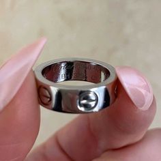 someone is holding a silver ring with the letter e on it's center finger