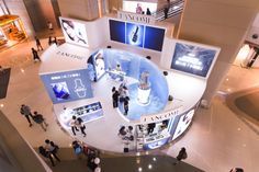 an overhead view of people shopping in a mall with chandeliers and advertisements on the walls