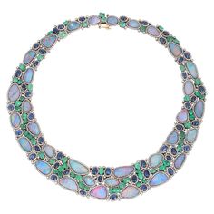 This stunning statement necklace is crafted in 18-karat gold and sterling silver. It is hand set in 70.0 carats opal doublets, 22.65 carats emerald, 27.37 carats blue sapphire and 11.41 carats of diamonds. FOLLOW MEGHNA JEWELS storefront to view the latest collection & exclusive pieces. Meghna Jewels is proudly rated as a Top Seller on 1stDibs with 5 star customer reviews. All items manufactured by us are handmade and can be customized or redesigned. Composition Gold Weight(Gms)-7.2 Silver Weigh