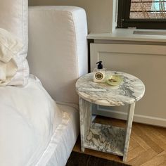 a marble topped table next to a white bed