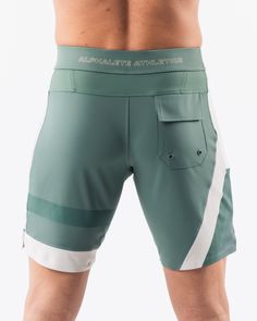 HIGHLIGHTS.. Unlined boardshort. 9” inseam Reflective branding at leg opening and back waistband Elastic waistband with adjustable self-tie drawcords Color-blocking panelling Water resistant fabric FIT SUGGESTION. This item runs true to Alphalete’s standard sizing.. Fit is based off of waist size in inches.. If you are between sizes, we recommend sizing up for a relaxed fit.. Eric is 6’2”/188cm, wearing a size 32. MATERIALS AND WASHING DIRECTIONS. 67% Nylon, 23% spandex. Due to the high saturati Fitted Swim Trunks With Pockets For Sports, Sporty Green Shorts With Functional Pockets, Green Training Bottoms With Pockets, Sporty Surfing Shorts With Pockets, Sporty Swimwear With Adjustable Waist Shorts, Sporty Swimwear With Adjustable Waist And Short Shape, Sporty Swimwear With Adjustable Waist, Sporty Surfing Bottoms With Elastic Waistband, Green Nylon Shorts With Functional Drawstring