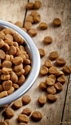 a bowl filled with dog food on top of a wooden table