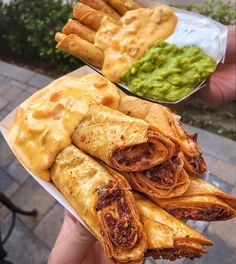 some tacos and guacamole are sitting on a table next to each other